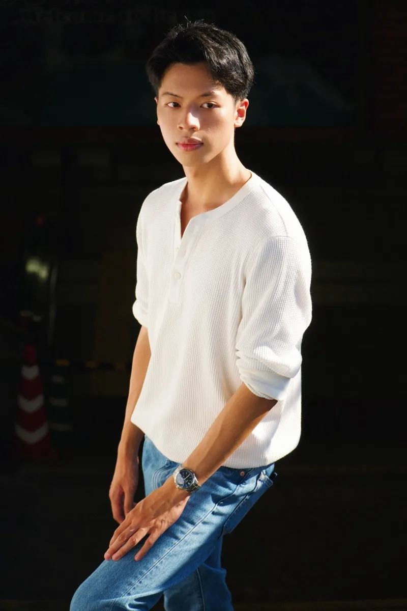 Pann Phetra in a white henley on a sunny street in Japan